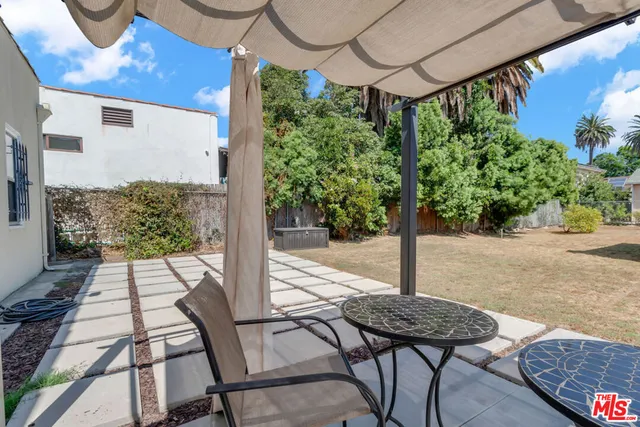 a view of a patio with a table and chairs with wooden fence