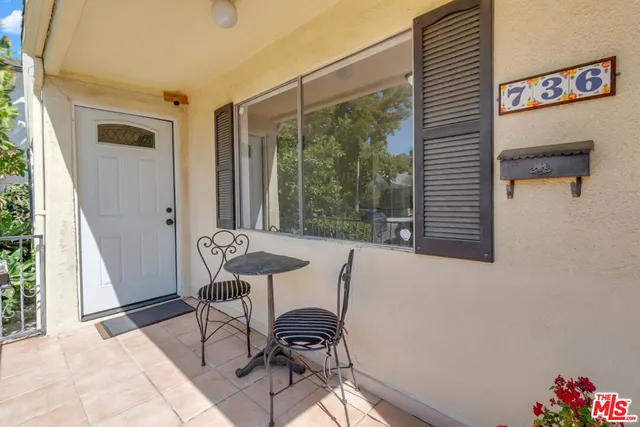 a view of a balcony with furniture and a potted plant