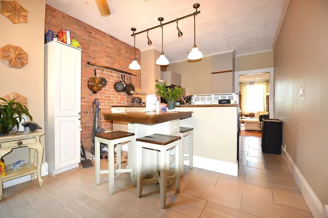 a kitchen with stainless steel appliances kitchen island granite countertop a table chairs and a refrigerator