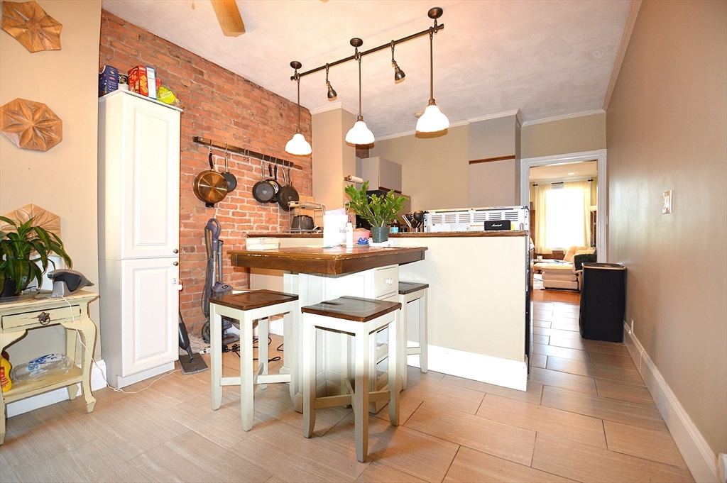 a kitchen with stainless steel appliances kitchen island granite countertop a table chairs and a refrigerator