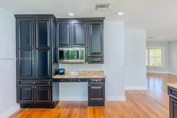 a kitchen with granite countertop wooden cabinets and stainless steel appliances