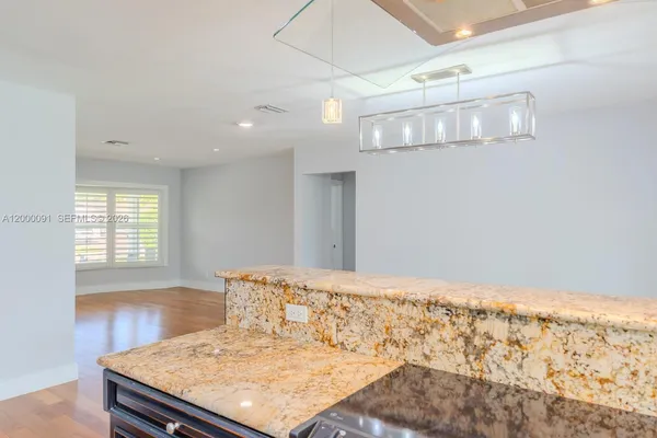a kitchen with stainless steel appliances granite countertop a refrigerator and a stove