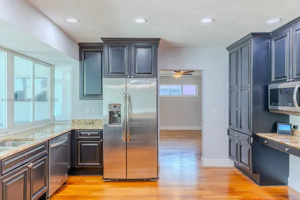 an empty room with wooden floor closet and windows