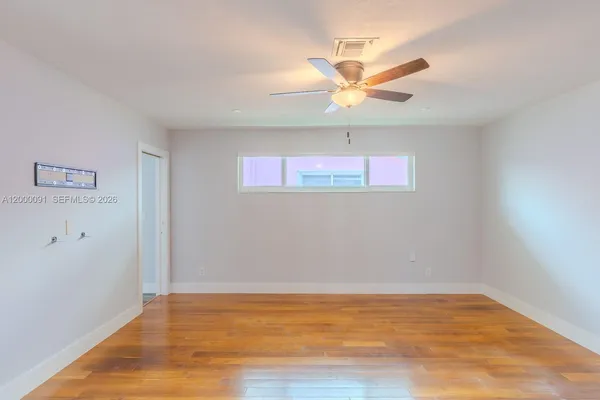 an empty room with wooden floor cabinet and closet