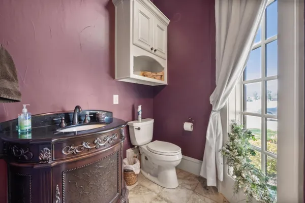 a bathroom with a toilet a sink and a mirror