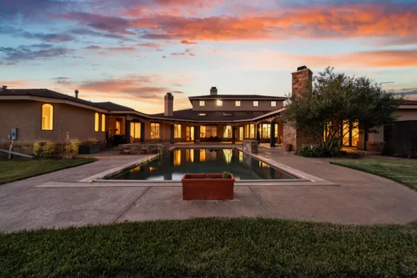 a view of a house with backyard and sitting area
