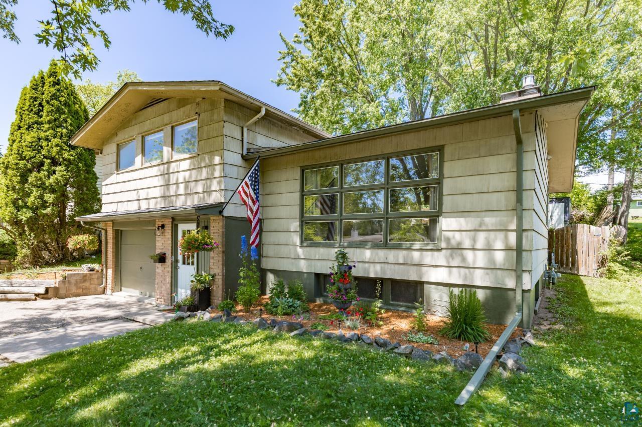 4119 Pitt Street Duluth, MN 55804 - Photo 24 of 50 Split-level residence featuring a single-car garage, brick accents, multi-pane windows, well-maintained landscaping, and mature surrounding trees