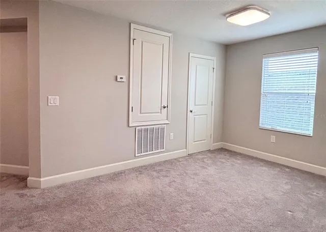 an empty room with a ceiling fan and wooden floor