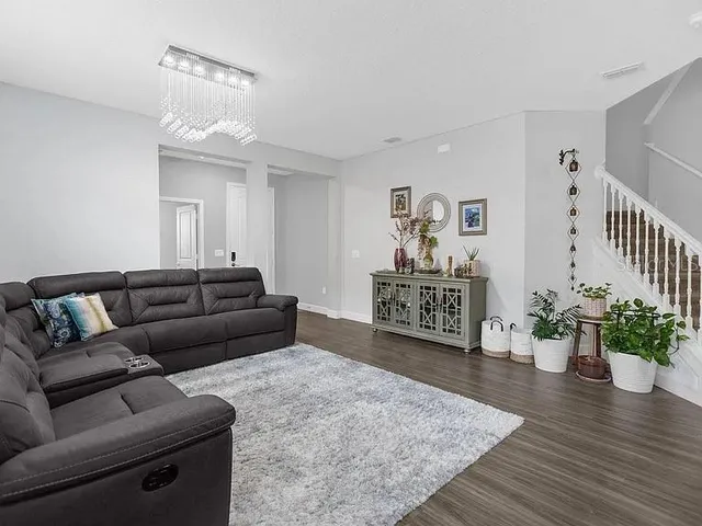 a living room with furniture and a chandelier