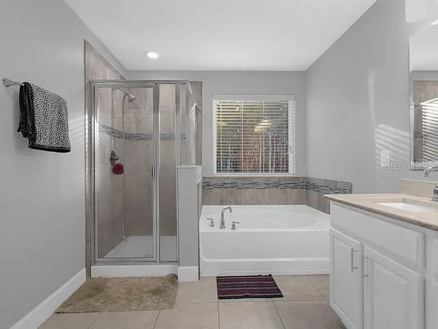 a bathroom with a tub shower and sink