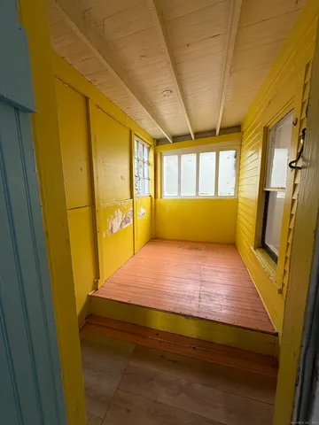 a view of hallway with wooden floor and furniture
