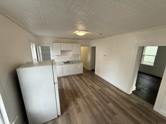 a view of a kitchen with wooden floor and a refrigerator