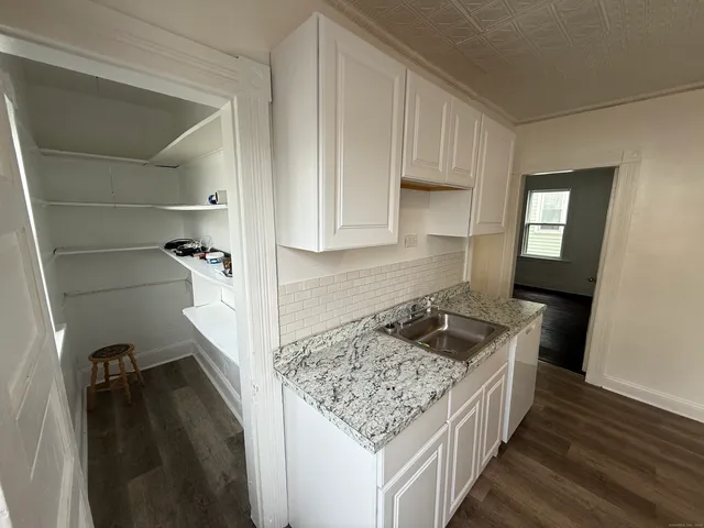 a kitchen with granite countertop a sink stove and cabinets