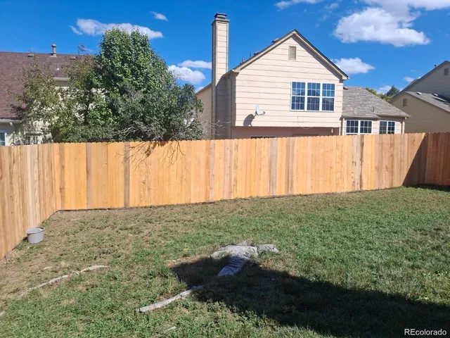 a view of backyard with wooden fence