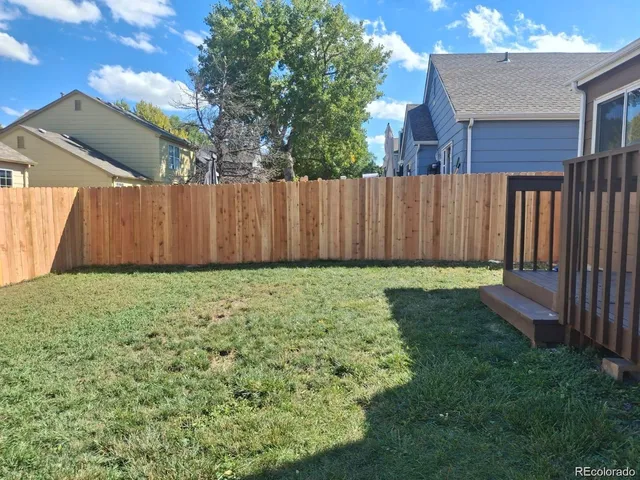 a view of a backyard with wooden fence