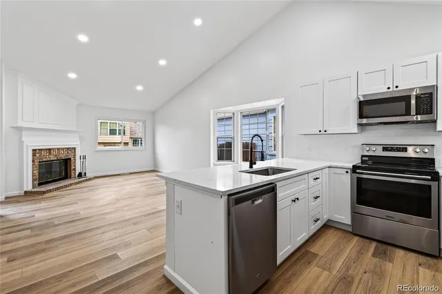 a kitchen with granite countertop a stove top oven and cabinets
