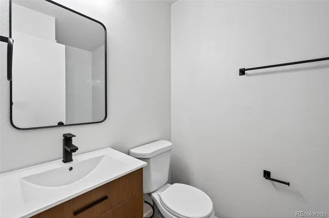 a bathroom with a sink a toilet and mirror