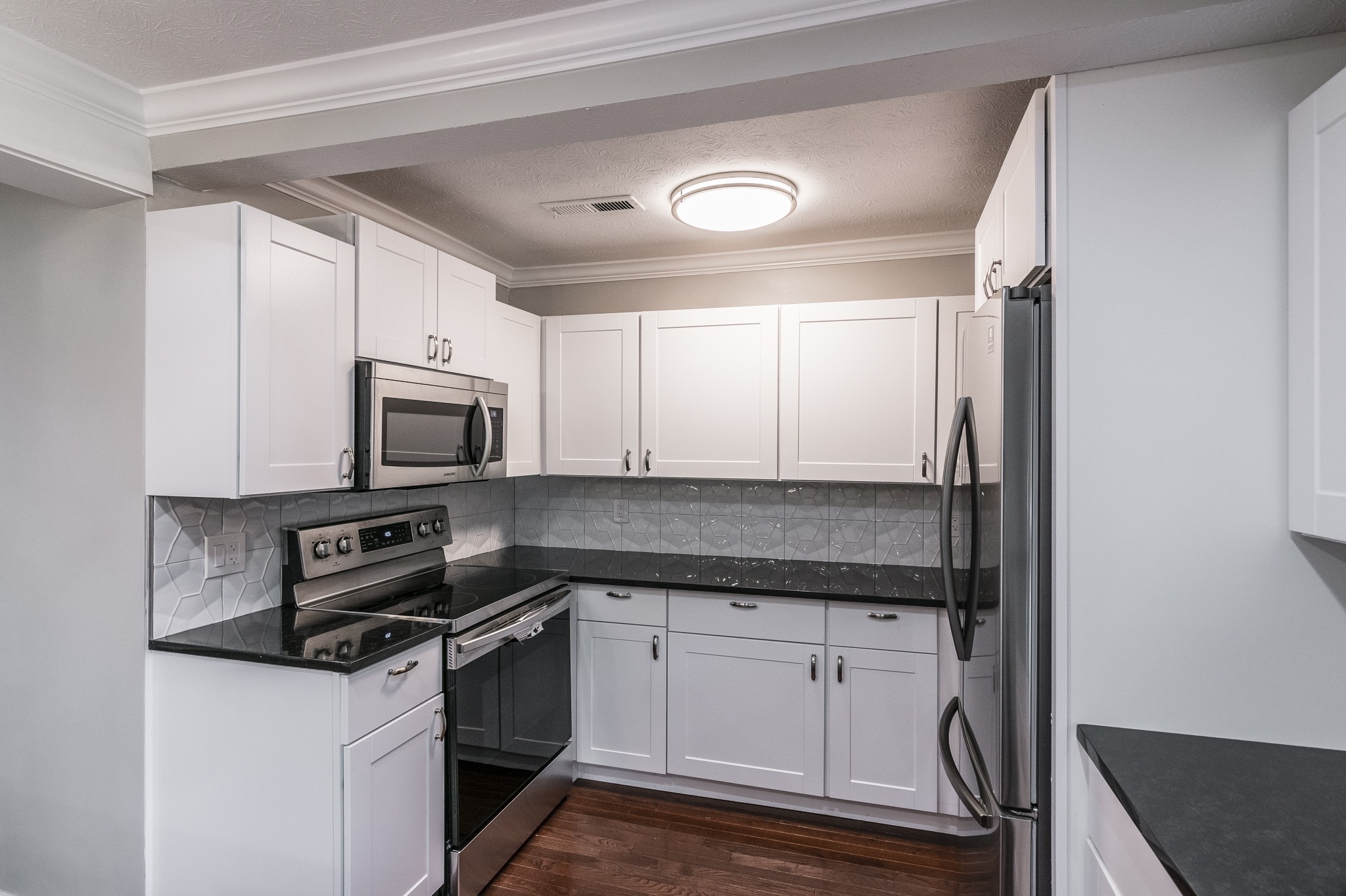 1267 Smiley Troutt Road Bethpage, TN 37022 - Photo 19 of 34 a kitchen with granite countertop a sink stainless steel appliances and white cabinets