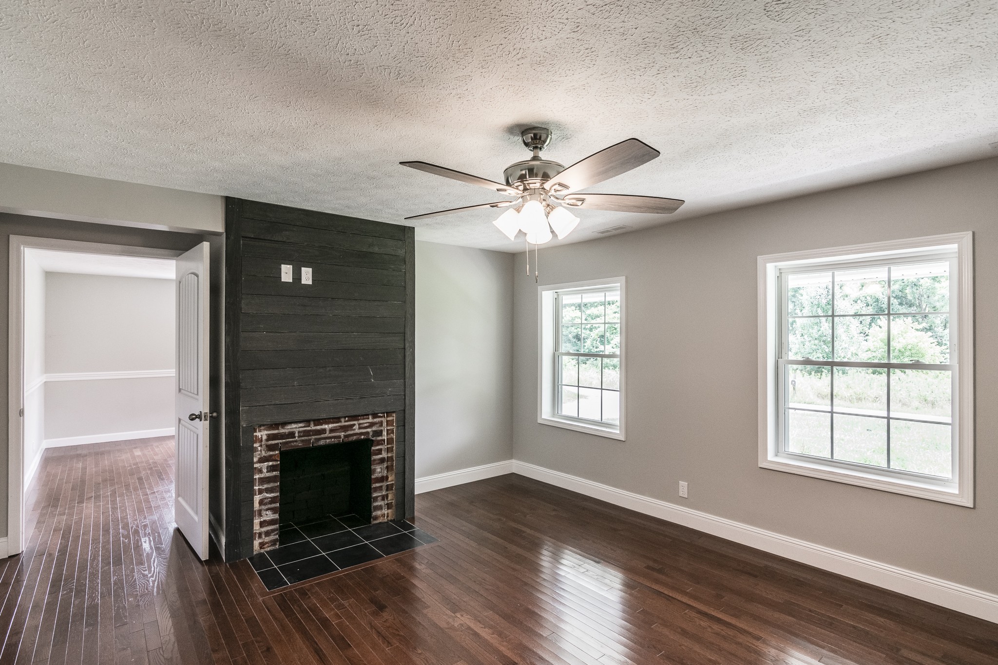 1267 Smiley Troutt Road Bethpage, TN 37022 - Photo 7 of 34 an empty room with wooden floor a fireplace and windows