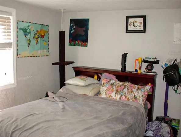 a bedroom with bed and painting on the wall