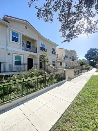 a view of a house with a small yard and wooden fence
