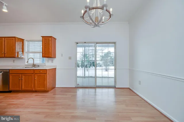 a view of a kitchen with a sink cabinet a fireplace and wooden floor