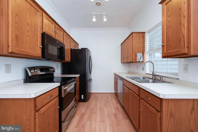 a kitchen with stainless steel appliances granite countertop a sink stove microwave and refrigerator