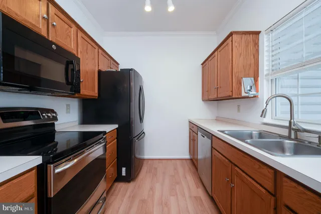 a kitchen with stainless steel appliances granite countertop a sink a stove a microwave and wooden cabinets