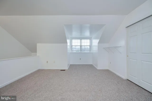 an empty room with white walls and windows