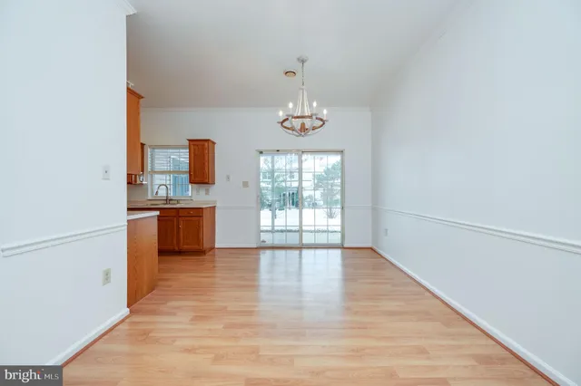 a view of a kitchen with a sink a window and wooden floor