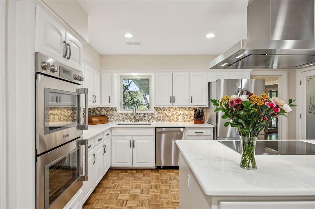 4708 Sugar Mill Road Dallas, TX 75244 - Photo 6 of 23 a kitchen with stainless steel appliances white cabinets and a counter top space