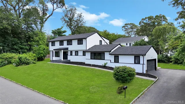 a front view of a house with a garden and trees