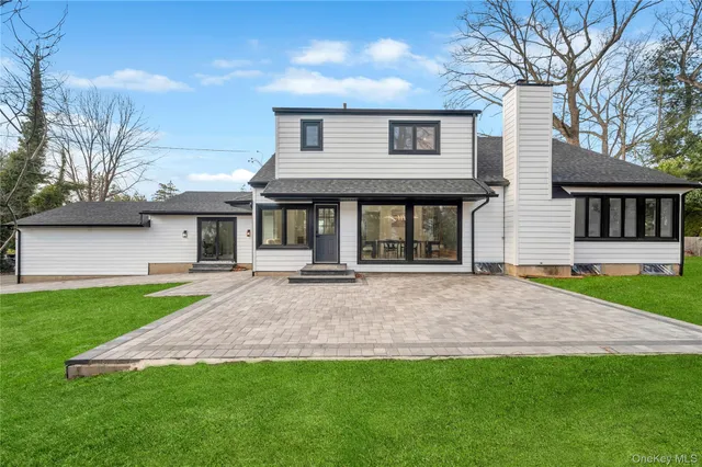 a front view of a house with a garden and yard
