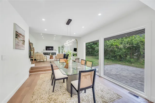 a dining room with furniture and a floor to ceiling window