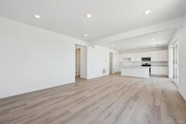 a view of empty room with wooden floor