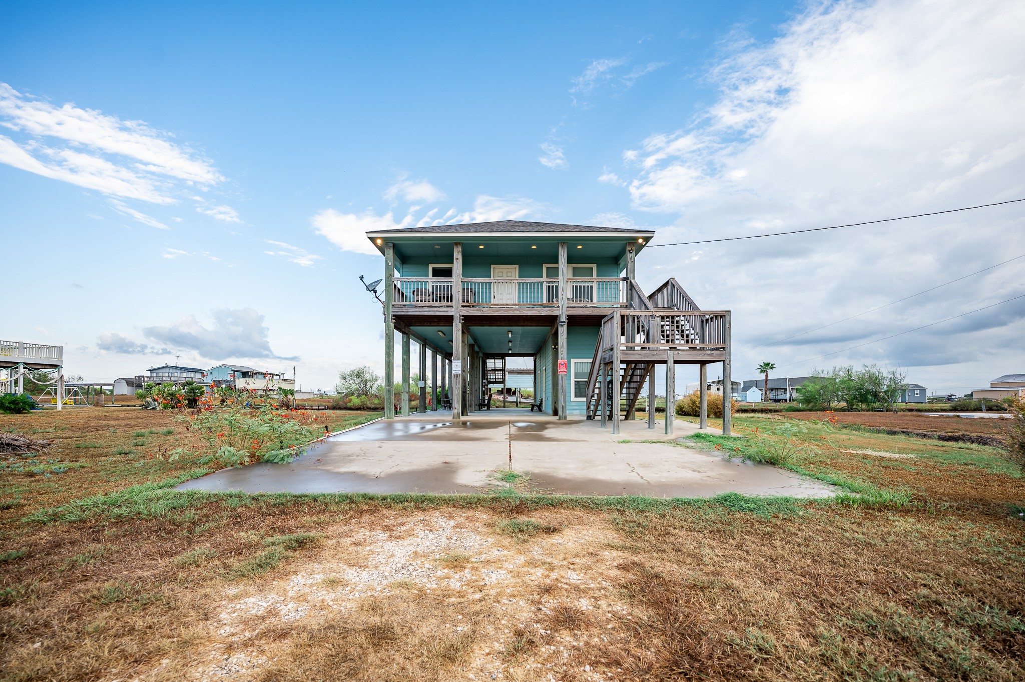 115 Albacore Street Sargent, TX 77414 - Photo 27 of 29 a front view of a house with a yard and balcony