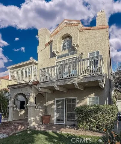 a view of building with garden space and a car park in front of it