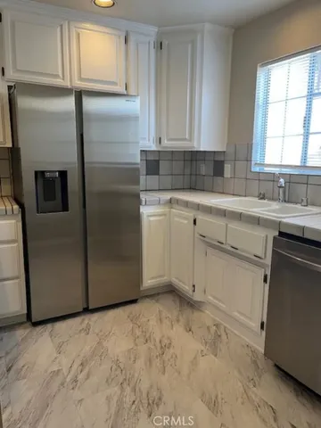 a kitchen with a refrigerator sink and cabinets