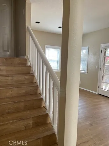 a view of staircase with lots of frames on wall and wooden floor