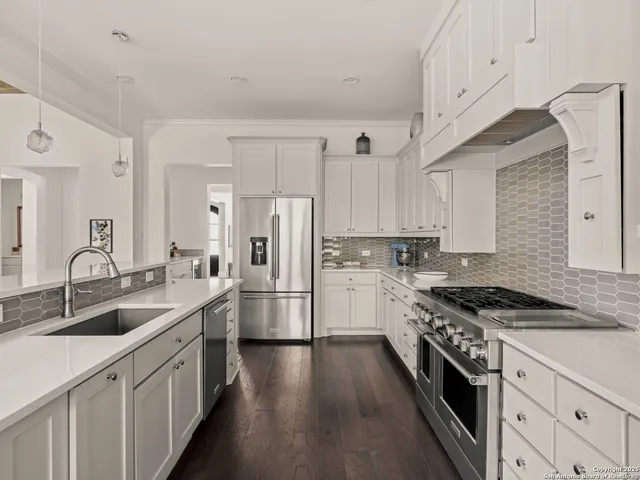 a kitchen with stainless steel appliances a sink stove and refrigerator