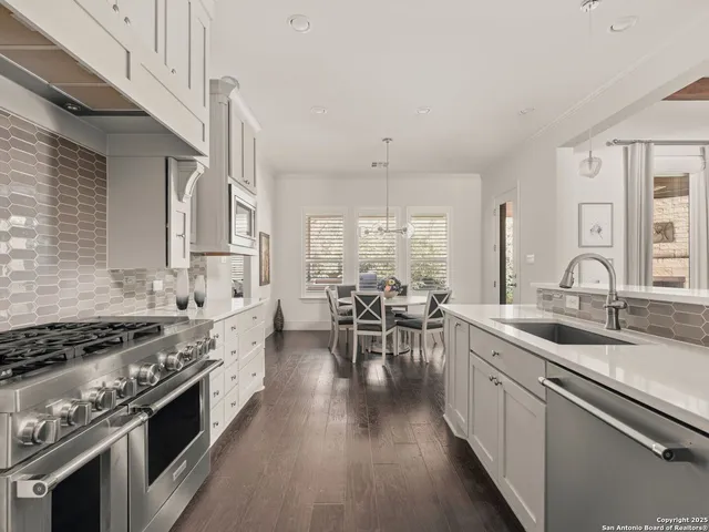 a kitchen with lots of counter top space a sink appliances and cabinets