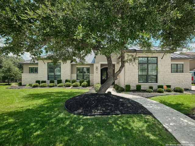 a view of a house with backyard and sitting area