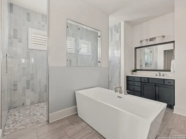 a white bath tub sitting next to a bathroom sink