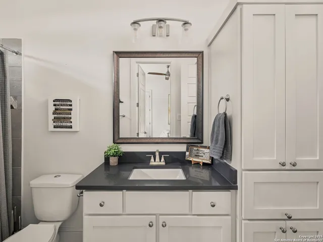 a bathroom with a granite countertop sink and a mirror