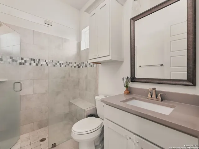 a bathroom with a granite countertop sink toilet and shower