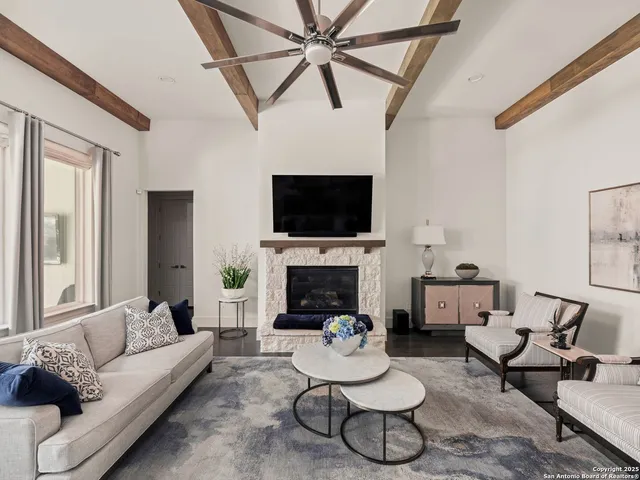 a living room with furniture a fireplace and a flat screen tv