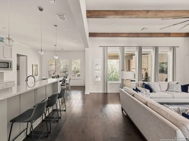 a large living room with stainless steel appliances kitchen island granite countertop furniture and a large window