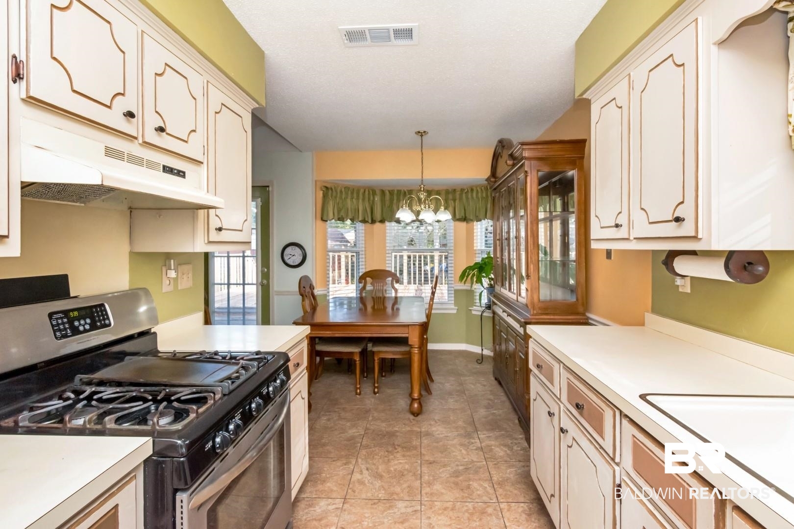 9360 Burnt Tree Drive Mobile, AL 36695 - Photo 12 of 28 Kitchen featuring gas range, sink, hanging light fixtures, a chandelier, and light tile patterned floors