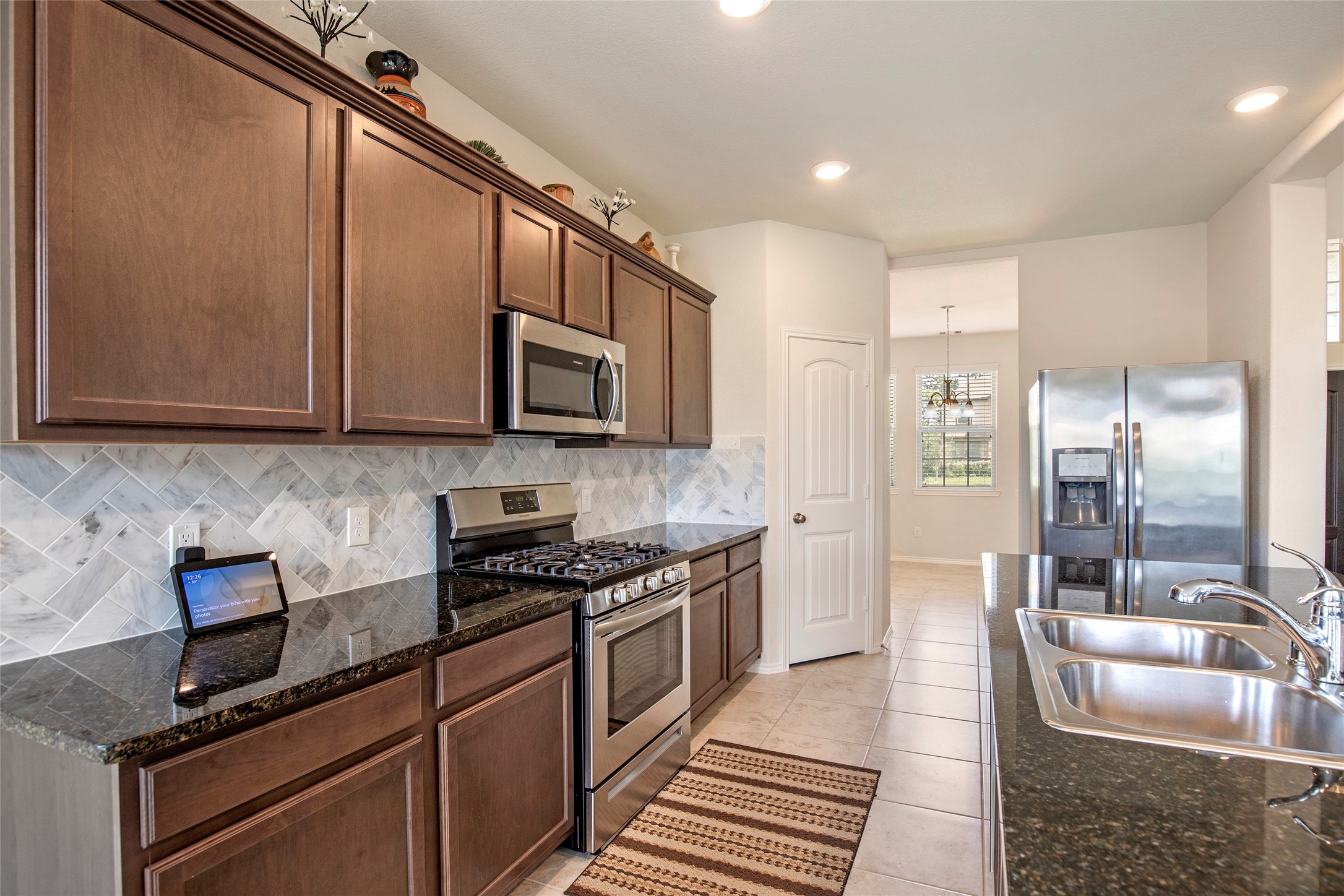 4519 Whitehaven Ridge Way Porter, TX 77365 - Photo 17 of 35 a kitchen with stainless steel appliances granite countertop a sink stove and microwave