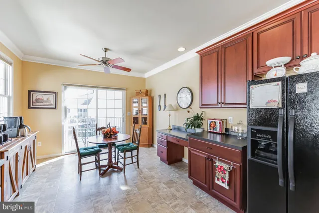 a open kitchen with stainless steel appliances granite countertop a stove top oven a sink dishwasher a dining table and chairs with wooden floor